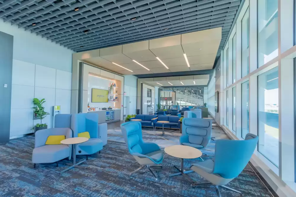 Ambiente de espera confortável e refrigerado da estação de trem da Brightline, com poltronas espaçosas e design moderno, oferecendo conforto aos passageiros entre Miami e Orlando.